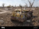 a-smashed-vehicle-and-ongoing-cleanup-operation-in-greensburg-kansas-AH374R.jpg